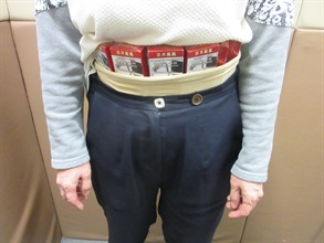 A 67-year-old incoming female passenger was sentenced to two months' imprisonment and fined $2,000 by the Fanling Magistrates' Courts today (January 14) for possessing duty-not-paid cigarettes and failing to declare them to Customs officers, in contravention of the Dutiable Commodities Ordinance. Photo shows the woman concealing the duty-not-paid cigarettes around her waist area.
