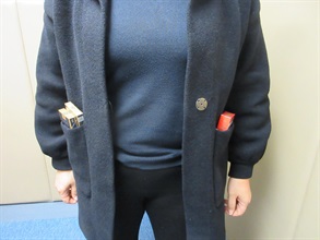 兩名入境旅客因管有未完稅香煙和未有向海關人員作出申報，違反《應課稅品條例》，今日（一月十九日）在粉嶺裁判法院分別被判處監禁四個月及罰款一千元，和監禁兩個月。圖示一名旅客把未完稅香煙藏於外套口袋內。