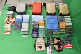 Two incoming passengers were sentenced to seven months’ imprisonment and fined $500 respectively by the West Kowloon Magistrates' Courts today (February 23) for dealing with duty-not-paid cigarettes, failing to declare them to Customs officers, as well as importing alternative smoking products, in contravention of the Dutiable Commodities Ordinance and the Import and Export Ordinance. Photo shows the duty-not-paid cigarettes and the alternative smoking products seized from the personal baggage of the two passengers.