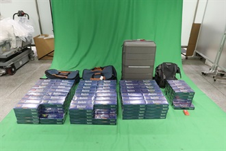 三名入境旅客因進口未完稅香煙、未有向海關人員作出申報，以及進口另類吸煙產品，違反《應課稅品條例》和《進出口條例》，今日（三月九日）在西九龍裁判法院分別被判處監禁六個月和罰款九百元、監禁七個月和罰款一千元，以及監禁四個月和罰款一千元。圖示於一名六十歲男旅客的個人行李內檢獲的未完稅香煙。