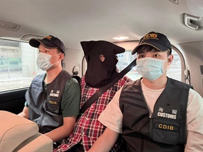 香港海关在香港国际机场侦破三宗行李藏毒的贩毒案件，共检获约二十二公斤怀疑氯胺酮、约二十一公斤怀疑大麻花、约九点五克无烟烟草、一支另类吸烟产品和两粒电子烟弹，估计市值共约一千三百万元，并拘捕三名男子。图示第二宗案件中的被捕人士（中）。