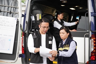 香港海关联同入境处今日（七月二十八日）上午在深圳湾管制站进行代号为「守望者」的跨部门反恐行动联合演习。图示入境处人员利用配备高精密鉴证仪器的流动鉴证战术车，鉴证该怀疑与恐怖组织有关的出境旅客所持的旅行证件。