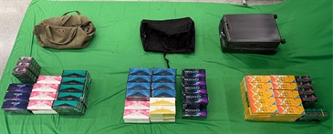 An incoming male passenger was sentenced to five months' imprisonment and fined $1,000 by the West Kowloon Magistrates' Courts today (May 29) for importing duty-not-paid cigarettes, failing to declare them to Customs officers, as well as importing alternative smoking products (ASPs), in contravention of the Dutiable Commodities Ordinance and the Import and Export Ordinance. Photo shows the duty-not-paid cigarettes and the ASPs seized.