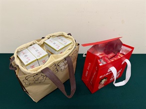 两名入境女旅客因进口或管有未完税香烟及未有向海关人员作出申报，违反《应课税品条例》，今日（六月二十三日）在粉岭裁判法院分别被判处监禁三个月及罚款一千元，以及监禁六星期和罚款二千元。图示一名四十九岁抵港本地女旅客第二次被截查时，海关人员在其携带的个人行李内检获的未完税香烟。