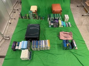 An incoming Chinese female passenger was sentenced to seven months' imprisonment and fined $1,000 by the West Kowloon Magistrates' Courts today (June 25) for importing duty-not-paid cigarettes, failing to declare them to Customs officers, as well as importing alternative smoking products (ASPs), in contravention of the Dutiable Commodities Ordinance and the Import and Export Ordinance. Photo shows the duty-not-paid cigarettes and ASPs seized.