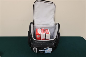 One incoming Mainland male passenger and two incoming local female passengers were sentenced to six weeks' imprisonment with a fine of $1,000 to ten months' imprisonment and a fine of $500 by the Courts today (July 6) for importing or possessing duty-not-paid cigarettes and failing to declare to Customs officers, in contravention of the Dutiable Commodities Ordinance. Photos shows an incoming 30-year-old local female passenger concealing the duty-not-paid cigarettes in the backpack carried by her accompanying child.