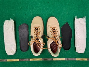 Hong Kong Customs yesterday (July 14) and today (July 15) detected two drug trafficking cases involving incoming air passengers at Hong Kong International Airport and seized about 2.5 kilograms of suspected cannabis buds and 1kg of suspected cocaine with a total estimated market value of about $1.21 million. Photo shows the suspected cocaine seized and the shoes used to conceal the drug in the second case.