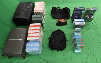 Three incoming passengers were sentenced to six to seven months’ imprisonment and fined $800 to $1,000, by the West Kowloon Magistrates' Courts yesterday (September 10) and today (September 11) for importing and dealing with duty-not-paid cigarettes, failing to declare them to Customs officers, as well as importing alternative smoking products, in contravention of the Dutiable Commodities Ordinance and the Import and Export Ordinance. Photo shows the duty-not-paid cigarettes and alternative smoking products seized from the personal baggage of a 56-year-old incoming Mainland male passenger.