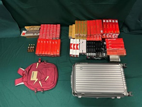 一名入境女旅客因管有未完稅香煙及烈酒和未有向海關人員作出申報，違反《應課稅品條例》，今日（九月十一日）在粉嶺裁判法院被判處監禁四個月及罰款兩千元。 圖示檢獲的未完稅香煙及烈酒和用作收藏未完稅香煙及烈酒的個人行李。