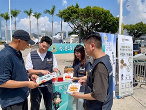 內地國慶黃金周將至，香港海關由昨日（九月二十九日）起加強巡查全港各區購物熱點，提醒商戶必須要遵守《商品說明條例》規定，以保障本地消費者和訪港旅客的消費權益。圖示海關人員在金紫荊廣場進行宣傳教育工作，如派發宣傳單張。