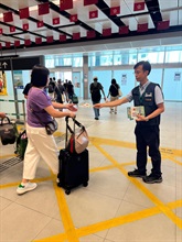 內地國慶黃金周將至，香港海關由昨日（九月二十九日）起加強巡查全港各區購物熱點，提醒商戶必須要遵守《商品說明條例》規定，以保障本地消費者和訪港旅客的消費權益。圖示海關人員在香園圍邊境管制站派發宣傳單張。