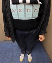 An incoming female passenger was sentenced to four weeks' imprisonment with a fine of $1,000 by the Fanling Magistrates' Courts today (October 12) for possessing duty-not-paid cigarettes and failing to declare them to Customs officers, in contravention of the Dutiable Commodities Ordinance. Photo shows the duty-not-paid cigarettes concealed around the waist of the female passenger.