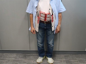 An incoming male passenger was sentenced to three months' imprisonment with a fine of $1,000 by the Fanling Magistrates' Courts today (October 22) for possessing duty-not-paid cigarettes and failing to declare them to Customs officers, in contravention of the Dutiable Commodities Ordinance. Photo shows the male passenger concealing the duty-not-paid cigarettes in the inner pockets of a vest worn by him and around his waist.