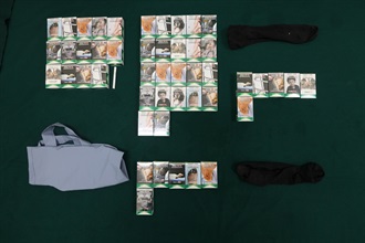 An incoming female passenger was sentenced to six weeks' imprisonment with a fine of $1,500 by the Fanling Magistrates' Courts today (October 28) for possessing duty-not-paid cigarettes and failing to declare them to Customs officers, in contravention of the Dutiable Commodities Ordinance. Photo shows the duty-not-paid cigarettes seized, and the recycle bag and clothing used to conceal the duty-not-paid cigarettes.