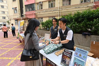 Hong Kong Customs today (October 28) conducted joint anti-illicit cigarette publicity campaigns with the Tobacco and Alcohol Control Office of the Department of Health and the Housing Department at Model Housing Estate in Quarry Bay. Customs also publicised the Duty Stamp System. Photo shows Customs officers delivering anti-illicit cigarette messages to a resident.
