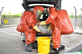 Hong Kong Customs and the Fire Services Department (FSD) co-organised a counter-terrorism intelligence and hazardous material incident exercise codenamed "DEFENDER" yesterday afternoon (May 23) at the Customs Inbound Private Car Examination Building of the Heung Yuen Wai Boundary Control Point. Photo shows FSD officers wearing Level A chemical protection suits handling suspected leakage of hazardous material at the scene.